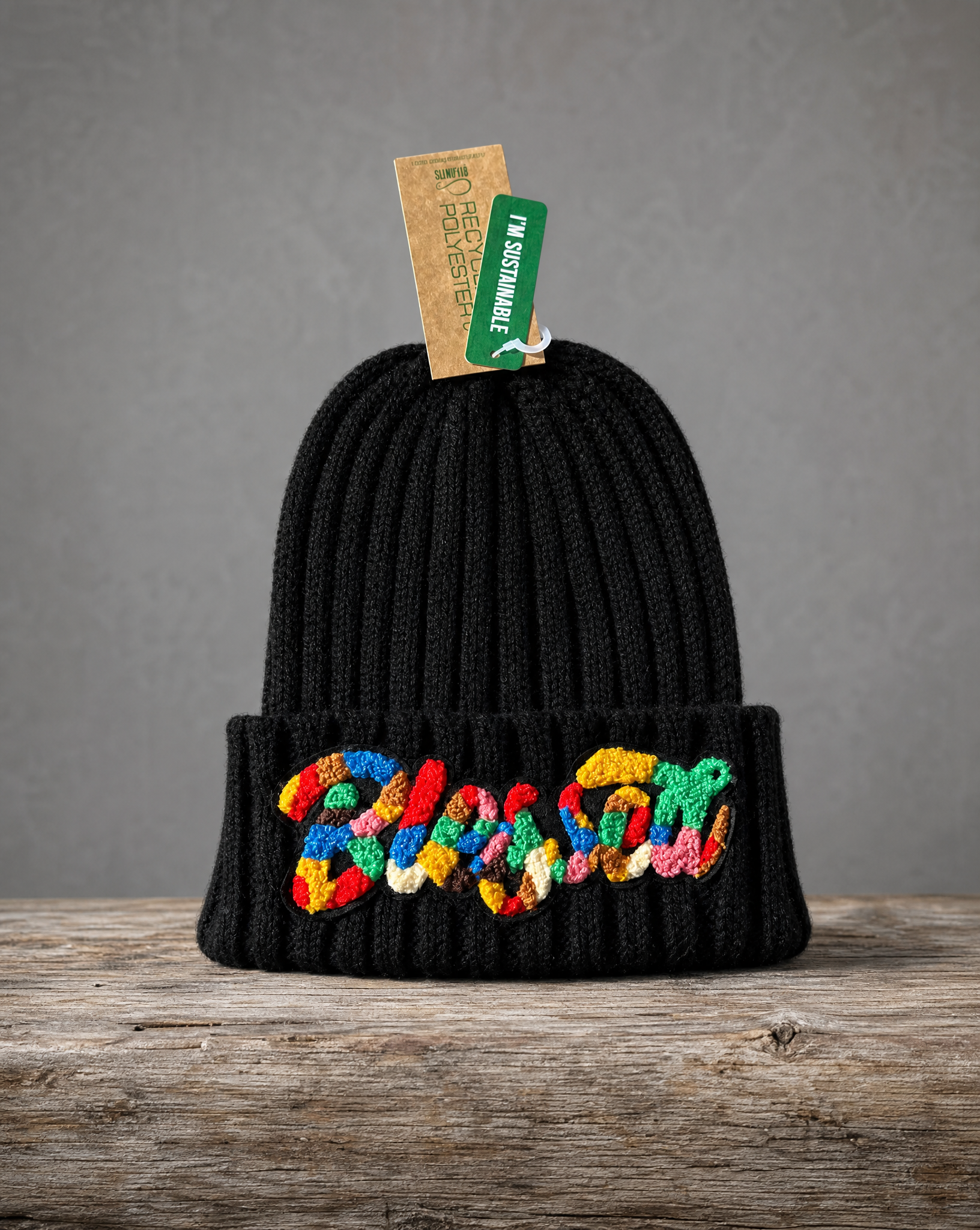 Black sustainable cable knit beanie featuring a handcrafted chenille Blessed patch