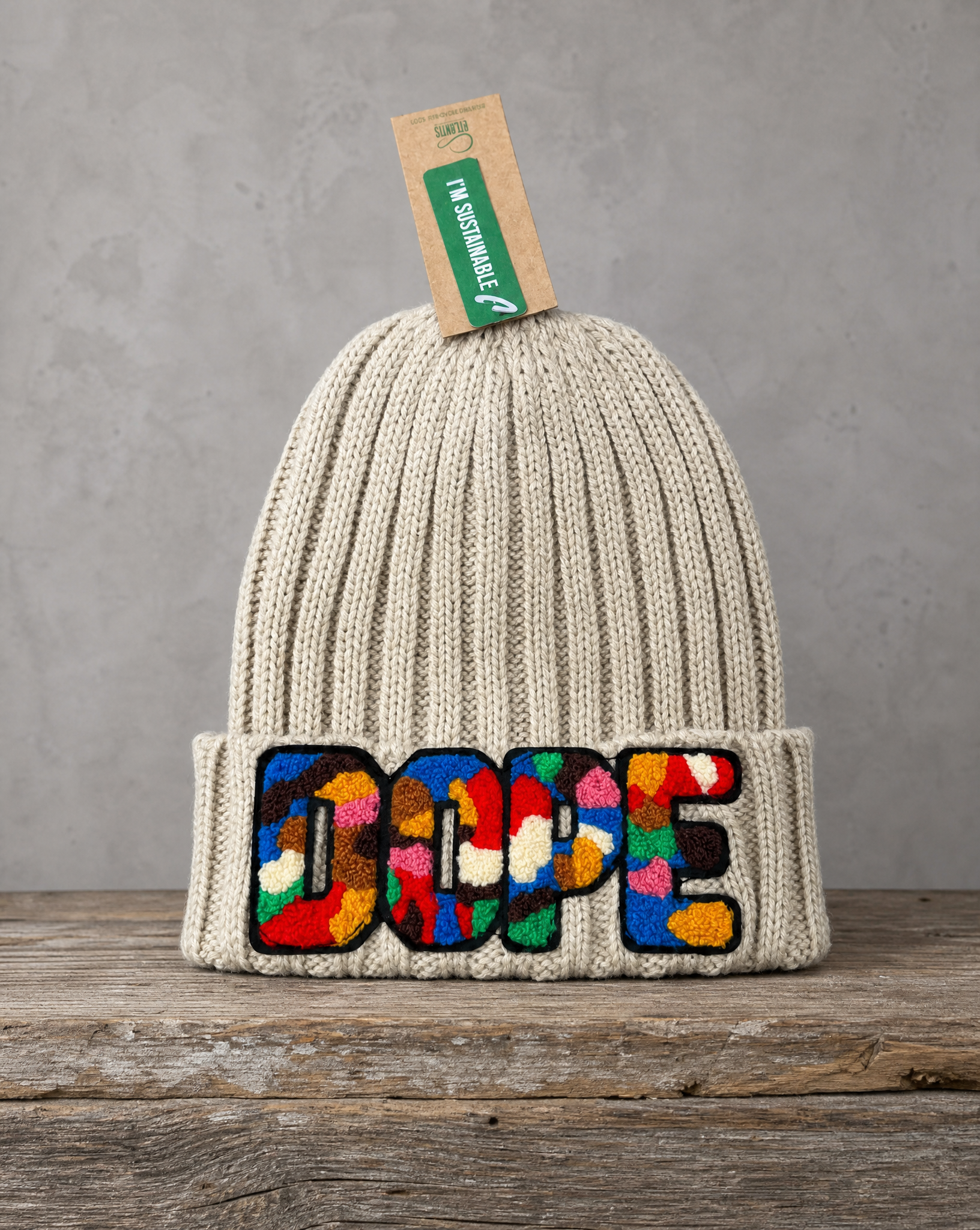 Beige cable knit beanie featuring a handcrafted chenille DOPE patch