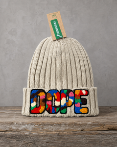 Beige cable knit beanie featuring a handcrafted chenille DOPE patch