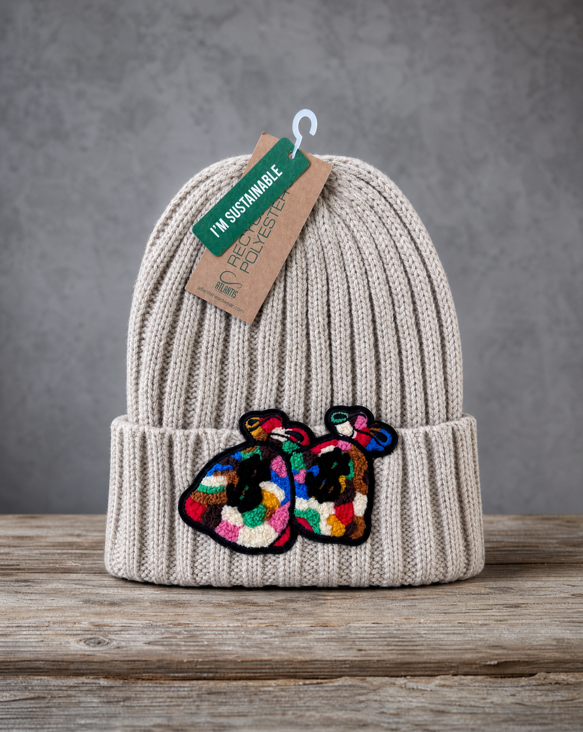 Beige cable knit beanie featuring a handcrafted chenille Money Bag patch