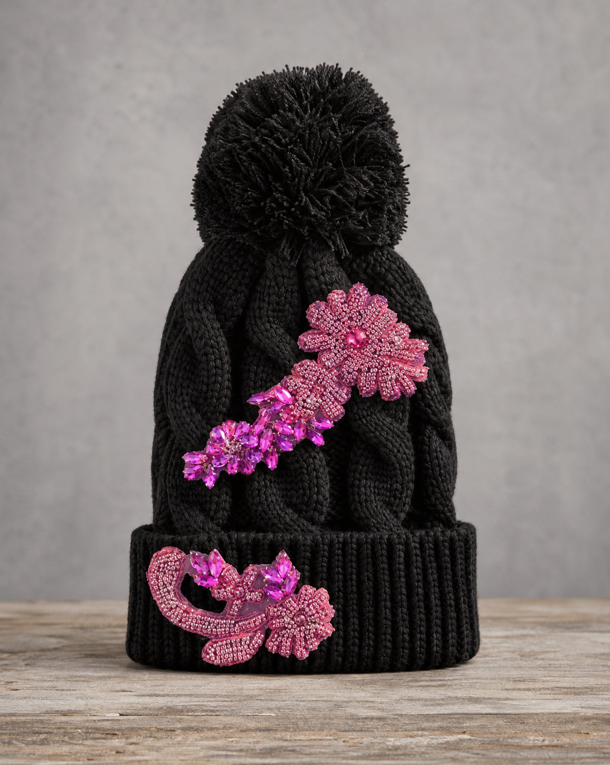Pink crystal appliqué cable knit pom beanie with handcrafted crystal embellishments