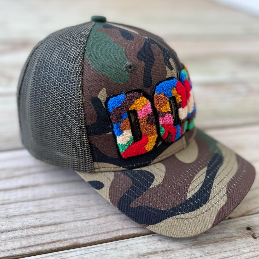 Left side view of camouflage trucker hat with colorful chenille DOPE patch and mesh back - Rebel P Customs