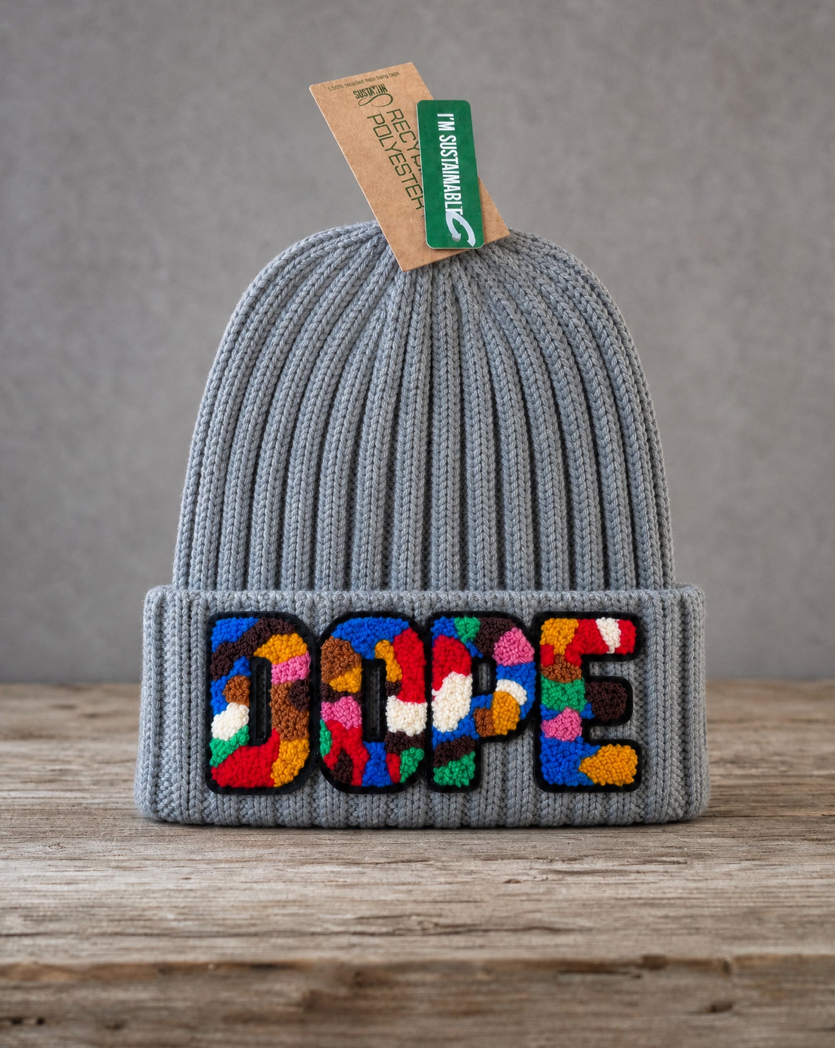 Gray cable knit beanie featuring a handcrafted chenille DOPE patch