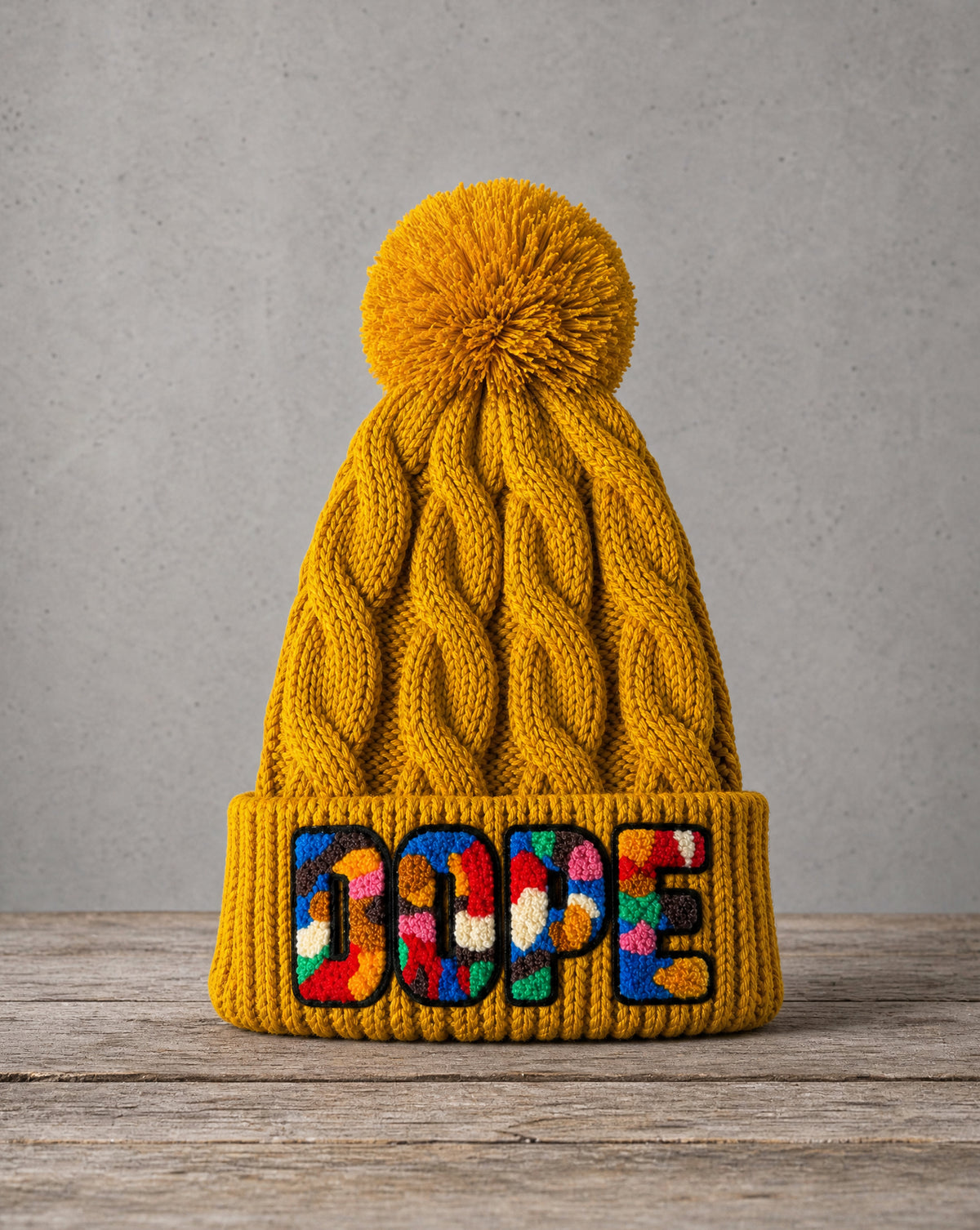 Chunky cable knit pom beanie featuring a handcrafted chenille DOPE patch