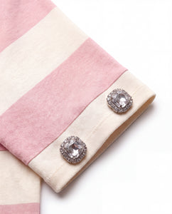 Close-up of hand-placed crystal embellishments on the sleeve of the pink striped polo