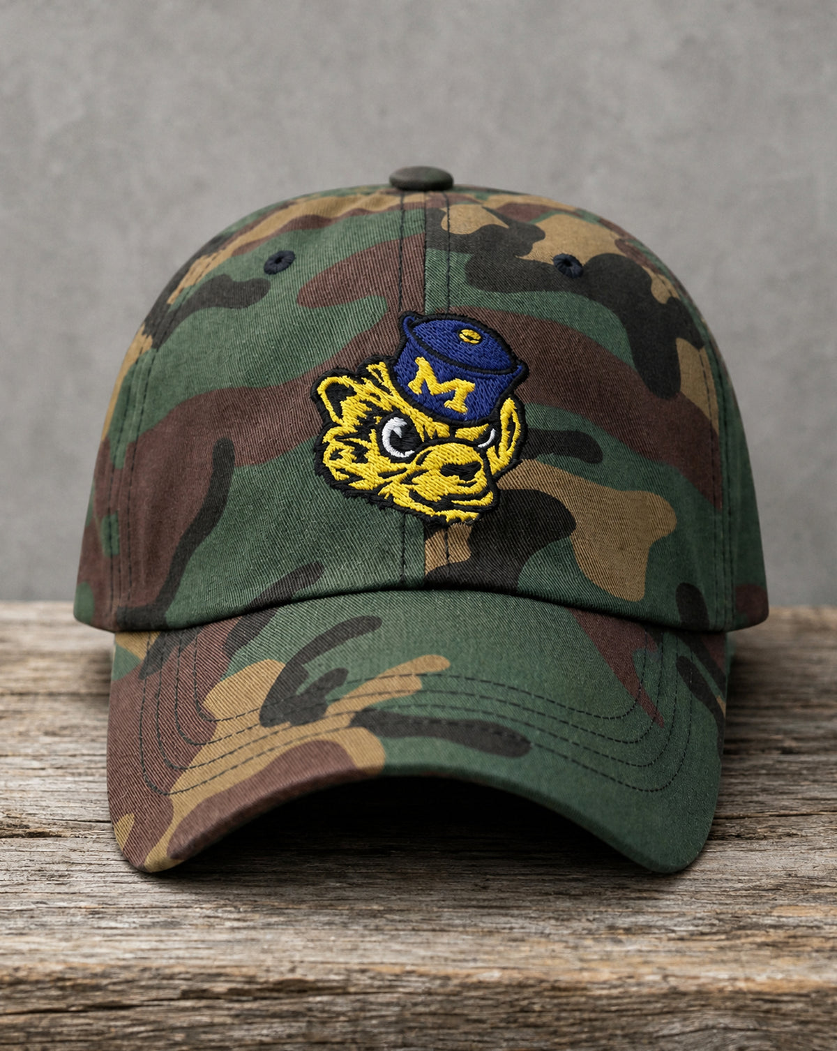 Hand-drawn Michigan wolverine mascot patch on a woodland camo hat, handcrafted City Collection by Believe In New York